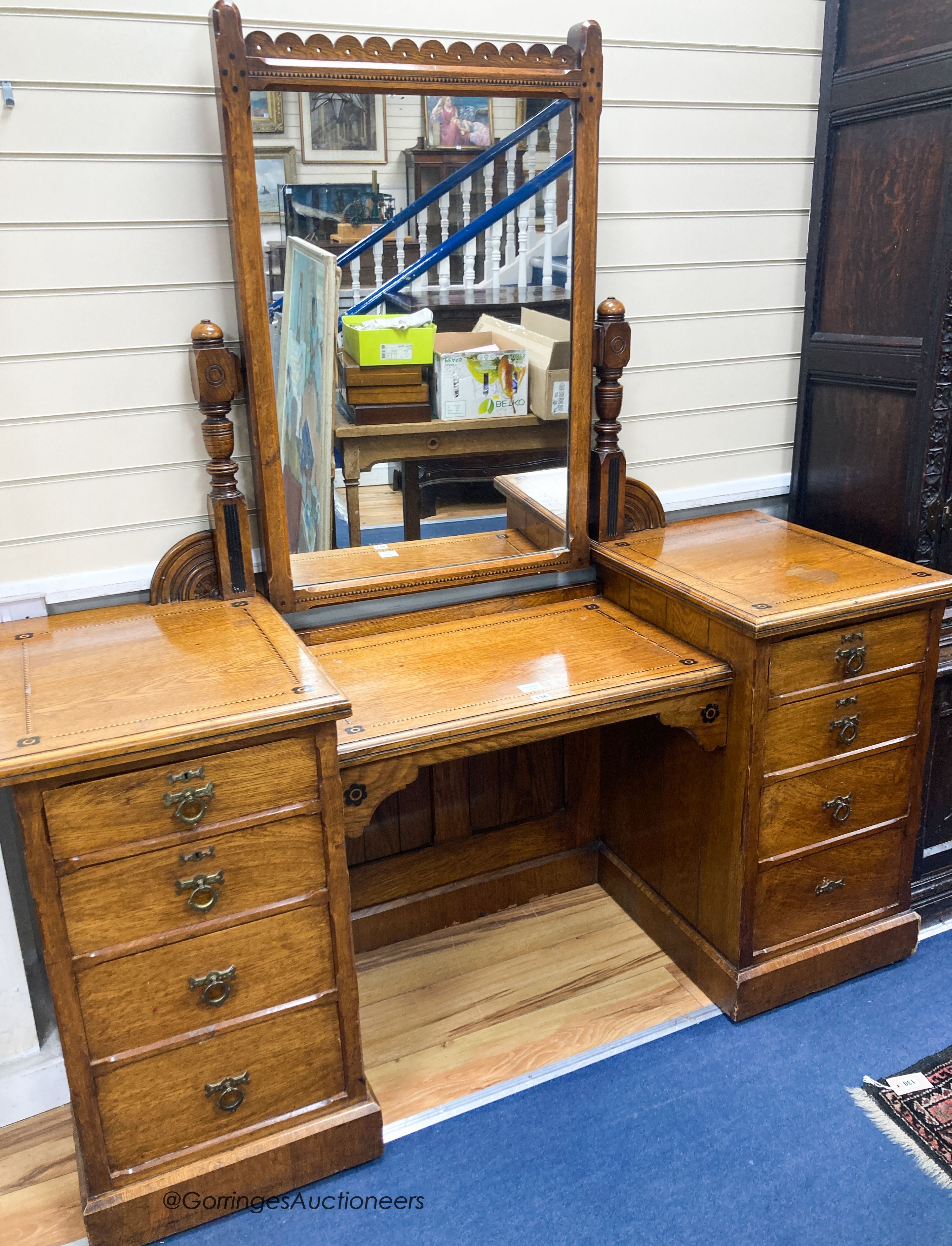 A late Victorian inlaid oak Aesthetic movement dressing table by Garnett & Son, Warrington, width 161cm, depth 59cm, height 176cm